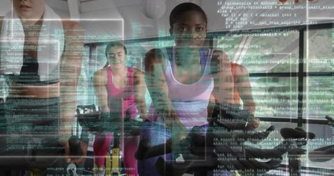 Women Exercising on Stationary Bikes with Digital Code Overlay