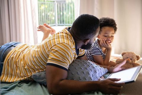 Father and Daughter Bonding with Tablet in Cozy Bedroom