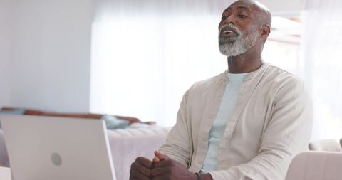 Mature African American Man Speaking on Remote Video Call in Bright Minimalist Home Office
