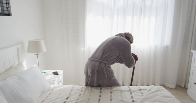 Senior Man with Cane Standing by a Bright Window in a Cozy Bedroom - Download Free Stock Images Pikwizard.com