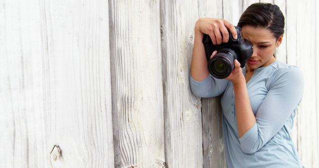 Photographer Capturing Moments with DSLR Camera Against Wooden Wall - Download Free Stock Images Pikwizard.com