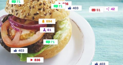 Gourmet sesame bun burger with lettuce and tomato showing social media engagement overlays