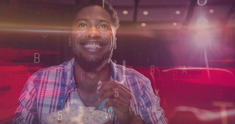 Joyful Man Enjoying Popcorn in Cinematic Experience