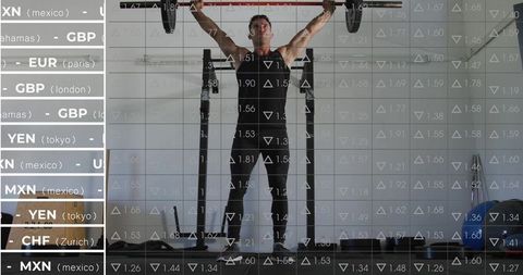 Athlete lifting loaded barbell overhead in industrial gym with financial market overlay