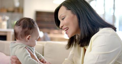 Mother Bonding with Baby at Home on Cozy Sofa