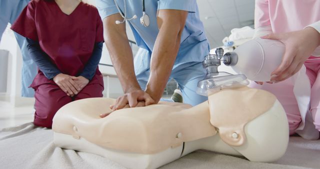 Medical professionals practice CPR on a training manikin. The healthcare workers are focused and dedicated to improving their skills in emergency response. This image is ideal for use in educational materials, healthcare training programs, and emergency procedure illustrations to demonstrate hands-on practice in life-saving techniques.