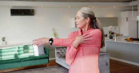 Senior Woman Stretching at Home Enhancing Wellness and Fitness in Modern Setting
