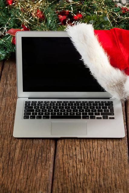 Laptop with santa hat on a plank