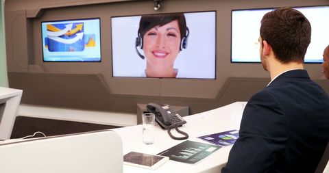 Business Conference Call with Smiling Woman on Monitor