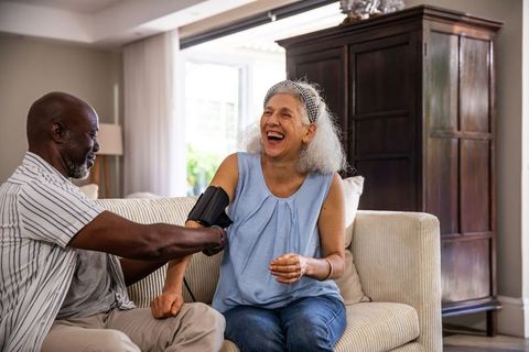 Senior Couple Enjoying Quality Time with Blood Pressure Monitor at Home