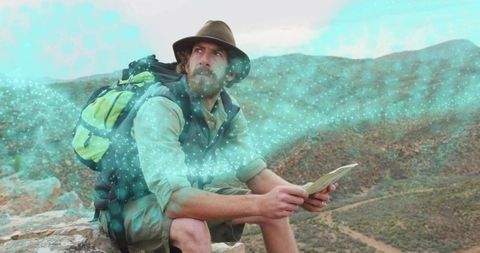 Adventurous hiker exploring canyon with map and digital effects