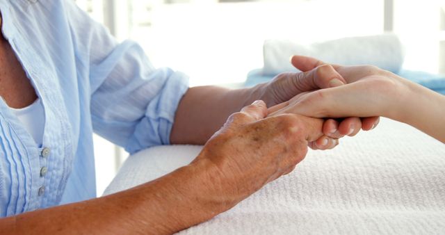 An elderly Caucasian person and a youth share a comforting, trusting handhold. - Download Free Stock Photos Pikwizard.com