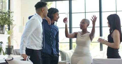 Stylish african american friends celebrating with champagne in modern sunlit lounge