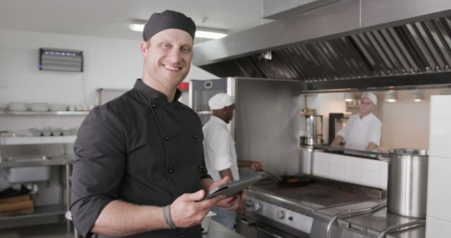 Smiling Chef with Tablet in Professional Kitchen - Download Free Stock Images Pikwizard.com