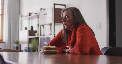 Contemplative Woman and Birthday Cake in Rustic Home Interior