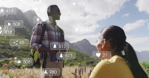 Couple hiking pausing in sunlit mountain meadow with floating social media notifications