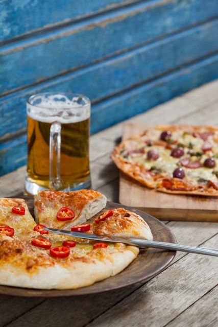 Delicious italian pizza served with glass of beer on wooden plank