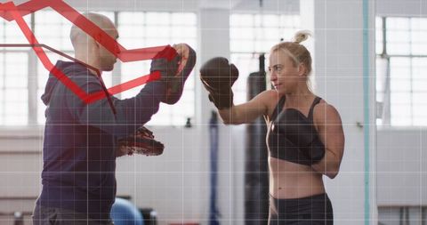 Female Boxer Training with Trainer Using Focus Mitts and Red Analytics Overlay in Gym
