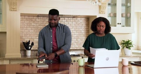 Mature Couple Analyzing Home Finances in Kitchen Environment