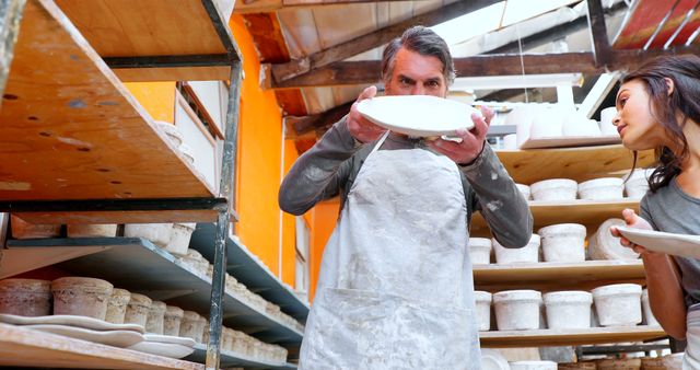 Male Ceramic Artist Examining Plate in Studio Workshop - Download Free Stock Images Pikwizard.com