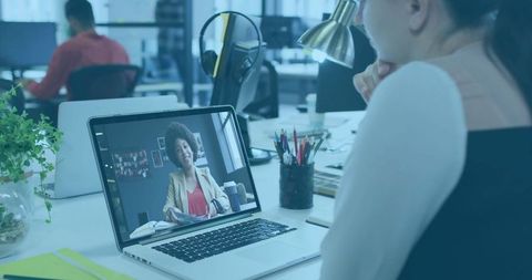 Asian professional engaged in videoconference at workplace