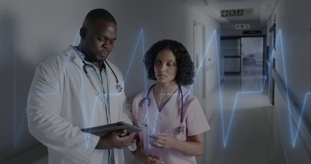 Doctors discussing patient charts in hospital hallway - Download Free Stock Images Pikwizard.com