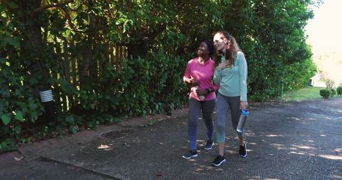 Friends Enjoying Outdoor Walk with Water Bottles in Sportswear