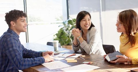 Diverse team collaborating with sketches and ideas in modern office