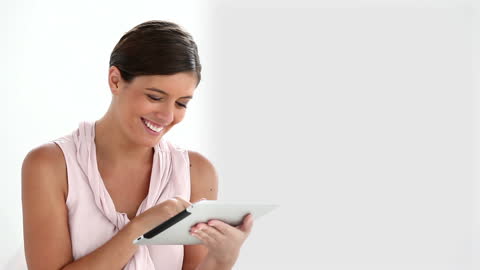 Smiling Woman Engaged with Tablet on White Background
