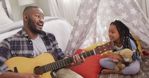 Father Playing Guitar with Daughter in Cozy Makeshift Tent