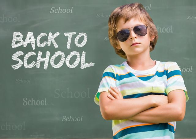 A confident young boy wearing sunglasses stands with his arms crossed in front of a chalkboard with 'Back to School' text. Ideal for education-related themes, marketing materials for school supplies, academic inspiration, or back-to-school campaigns.