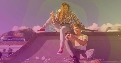 Couple relaxing at modern waterfront skate park