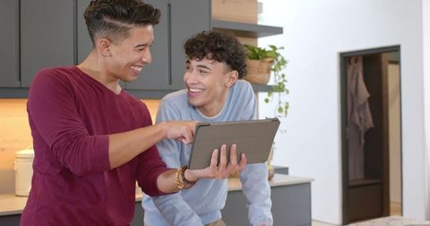 Two Friends Sharing Tablet Experience in Modern Kitchen