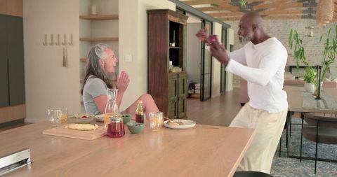 Senior Couple Sharing Playful Morning Breakfast in Modern Open-Plan Kitchen
