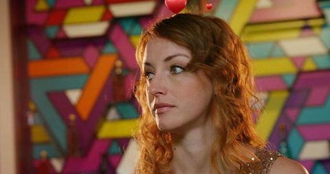 Thoughtful woman with curly hair against geometric background
