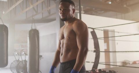 Determined Shirtless Boxer Training in Industrial Gym