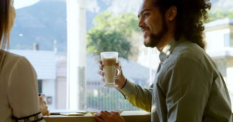 Caucasian Man Enjoying Latte in Cafe with Companion