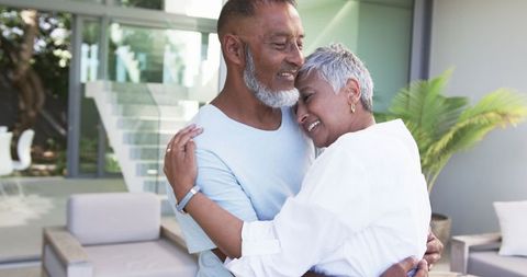 Senior couple embracing outdoors by modern veranda