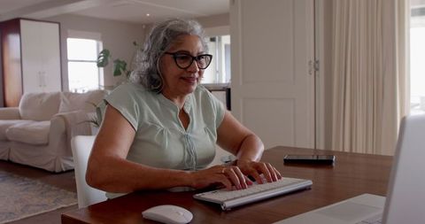 Senior woman video chatting at home on smartphone