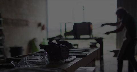 Skilled metalworker using tools in dimly lit workshop
