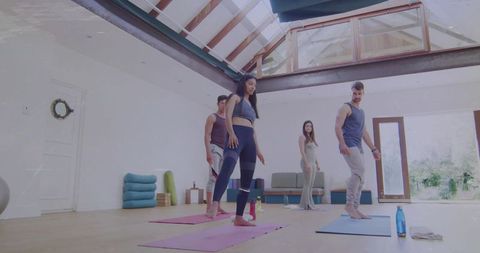 Diverse Group Practicing Yoga Poses in Contemporary Studio