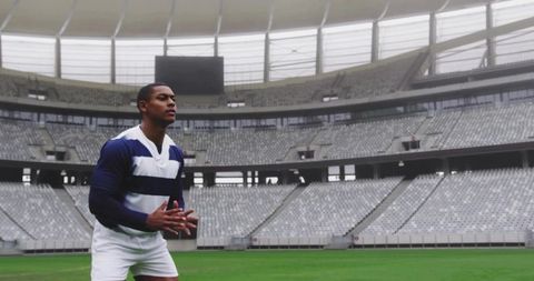 Athlete Preparing for Play in Empty Stadium Wearing Striped Jersey and White Shorts