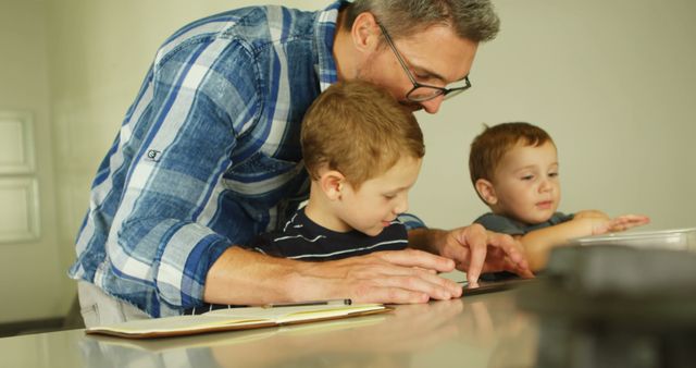 Father teaching young boys baking in the kitchen - Download Free Stock Images Pikwizard.com