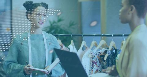 Fashion designer taking notes and measuring garments in boutique showroom collaboration