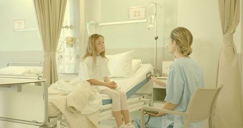 Young girl consulting nurse in pediatric hospital room with iv pole and bed rails