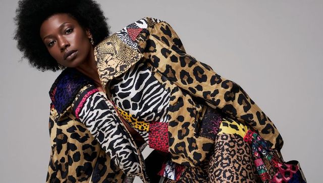 Leaning female model wearing patchwork animal-print jacket and patterned leggings