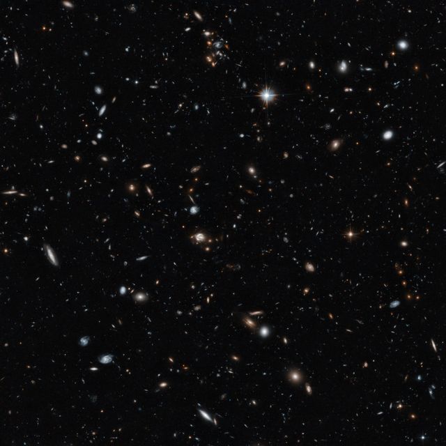 This image shows a variety of galaxies across different distances, captured by the Hubble Space Telescope. The image includes galaxies about five billion light-years from Earth and objects even farther away. Several groups of galaxies create an optical illusion of proximity. Gravitational lensing distorts some galaxies' images in the background, with notable lenses including the CLASS B1608+656 system. This composition, requiring 14 hours of Hubble exposure, reveals astronomically valuable details useful for research, presentations, science education, and articles on cosmic structures.