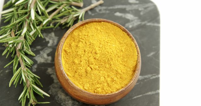 Turmeric Powder in Wooden Bowl with Fresh Rosemary on Marble Surface - Download Free Stock Images Pikwizard.com