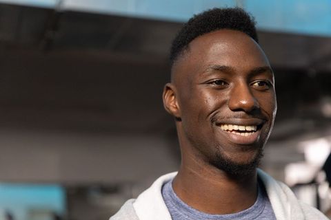 Confident african american man smiling in hoodie during urban commute lifestyle headshot