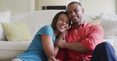 Smiling Couple Embracing on Living Room Floor